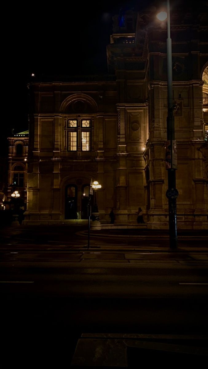 an old building lit up at night with street lights