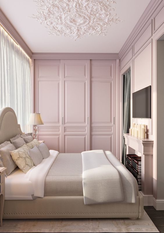 a bedroom with pink walls and white bedding in the center, along with a chandelier