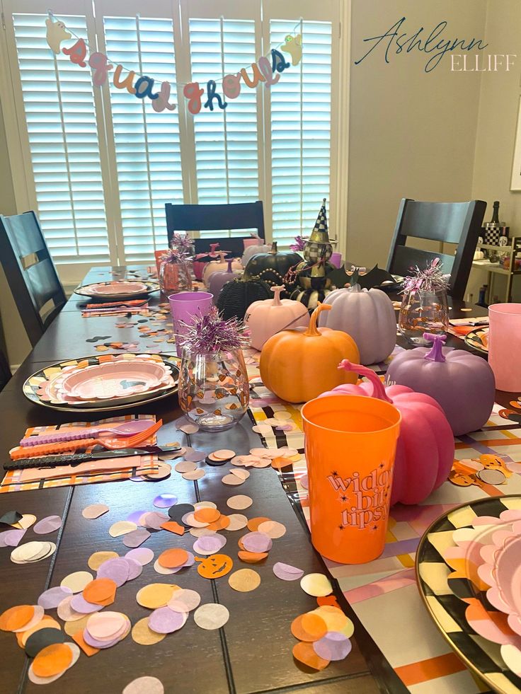 the table is set with plates, cups and napkins for halloween party guests to enjoy