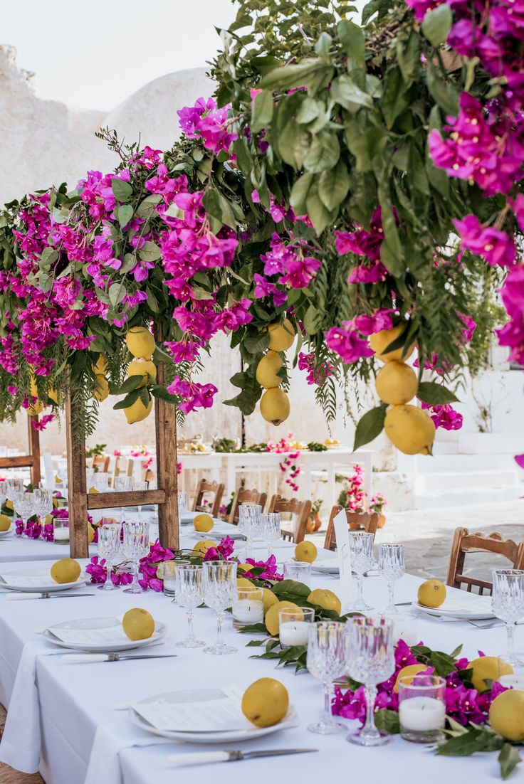 the tables are set with lemons and purple flowers