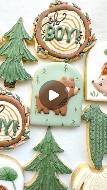 decorated cookies are arranged in the shape of trees and bears with words boy on them