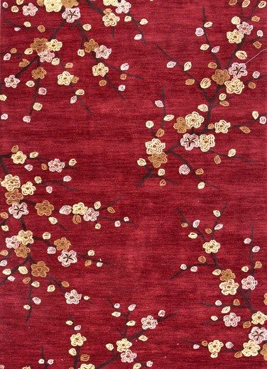 a red rug with gold and white flowers on the bottom, in front of a dark red background