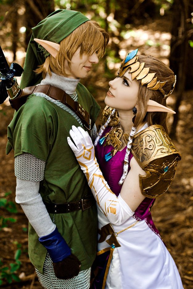 two people dressed up as elves in the woods, one is kissing the other's forehead