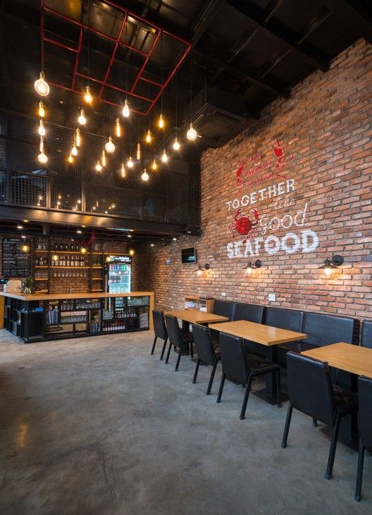 an empty restaurant with tables and chairs in front of a brick wall that reads together, good seafood