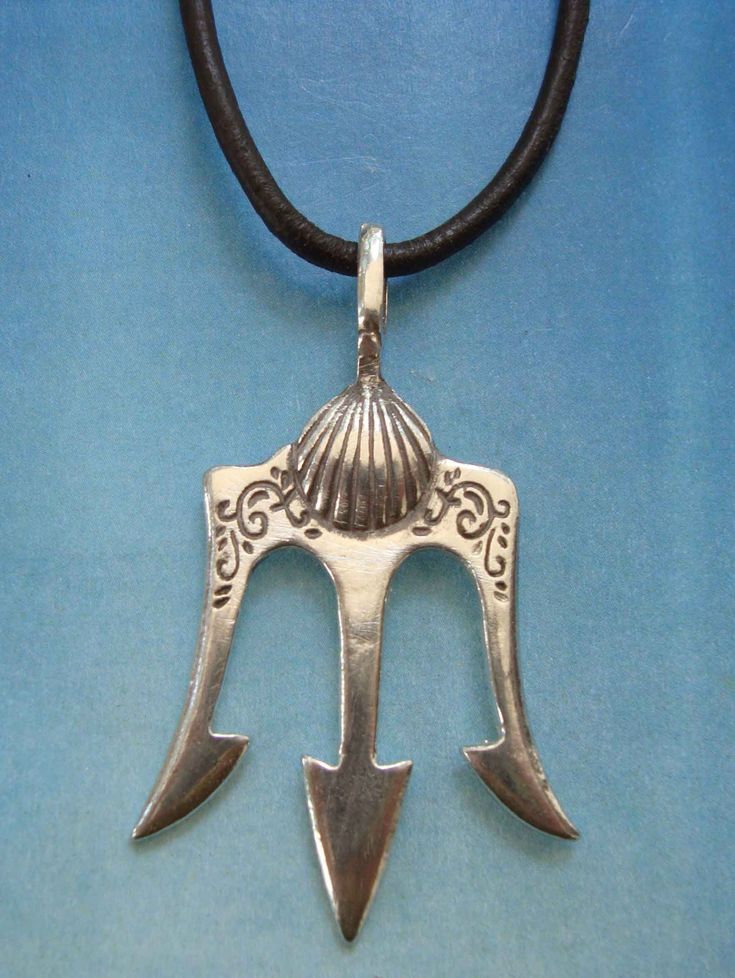 a silver pendant with an arrow on a black leather cord necklace that is attached to a blue background