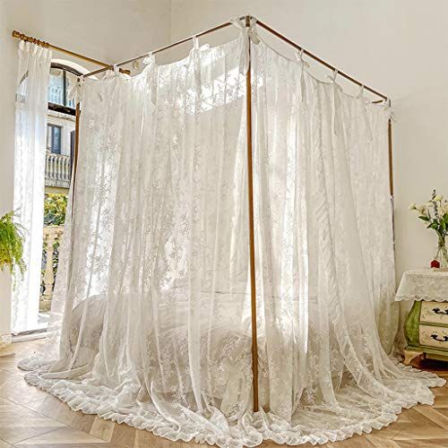 a canopy bed with sheer curtains in a room