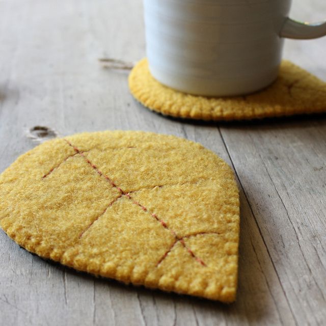 two cookies are sitting on a table with a white cup and saucer in the background