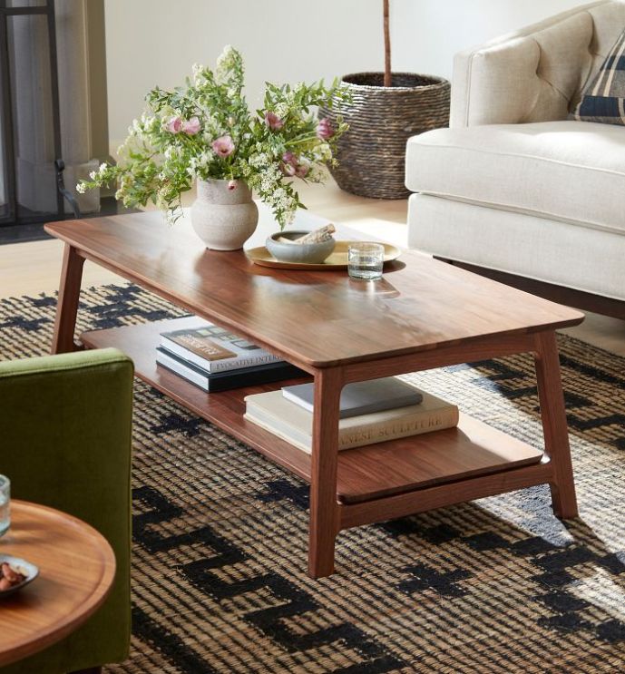 a living room filled with furniture and flowers on top of a coffee table in front of a couch