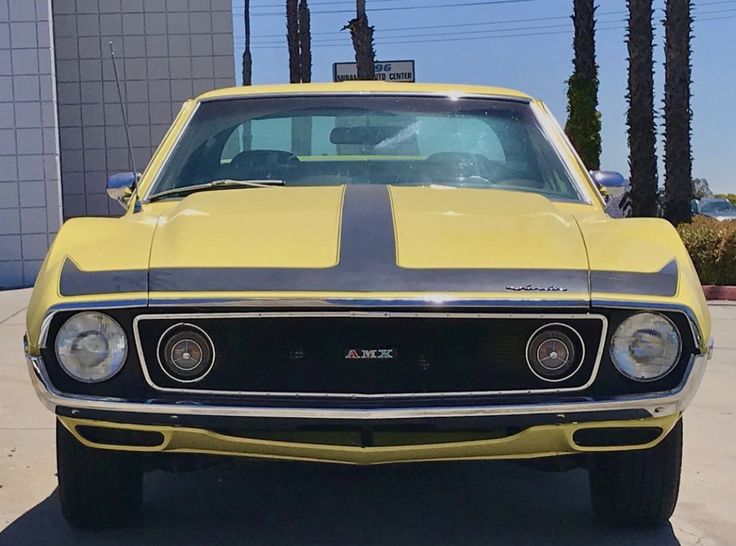 a yellow and black muscle car parked in a parking lot