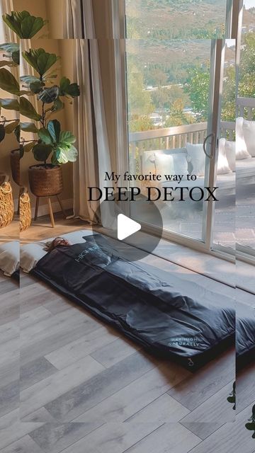 a bed sitting on top of a hard wood floor next to a large glass window