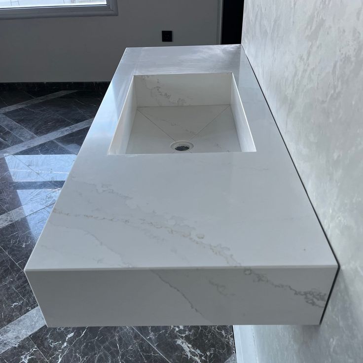 a white bathroom sink sitting on top of a counter