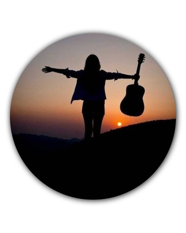 a woman holding an acoustic guitar in front of the sun at sunset with her arms outstretched