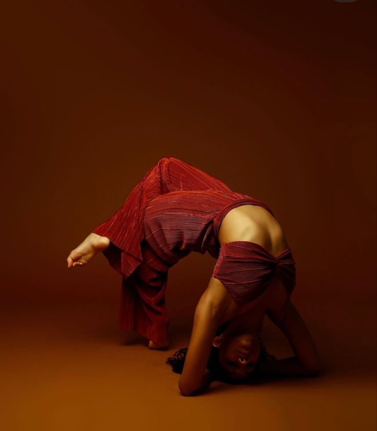 a woman in red is doing a handstand