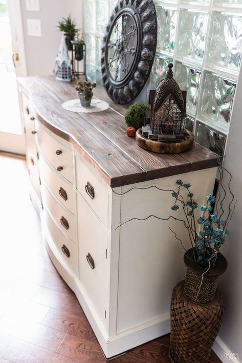 a white dresser with some plants on top of it