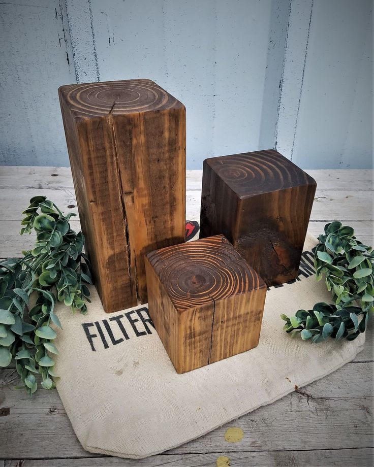 three pieces of wood sitting on top of a piece of cloth next to some plants