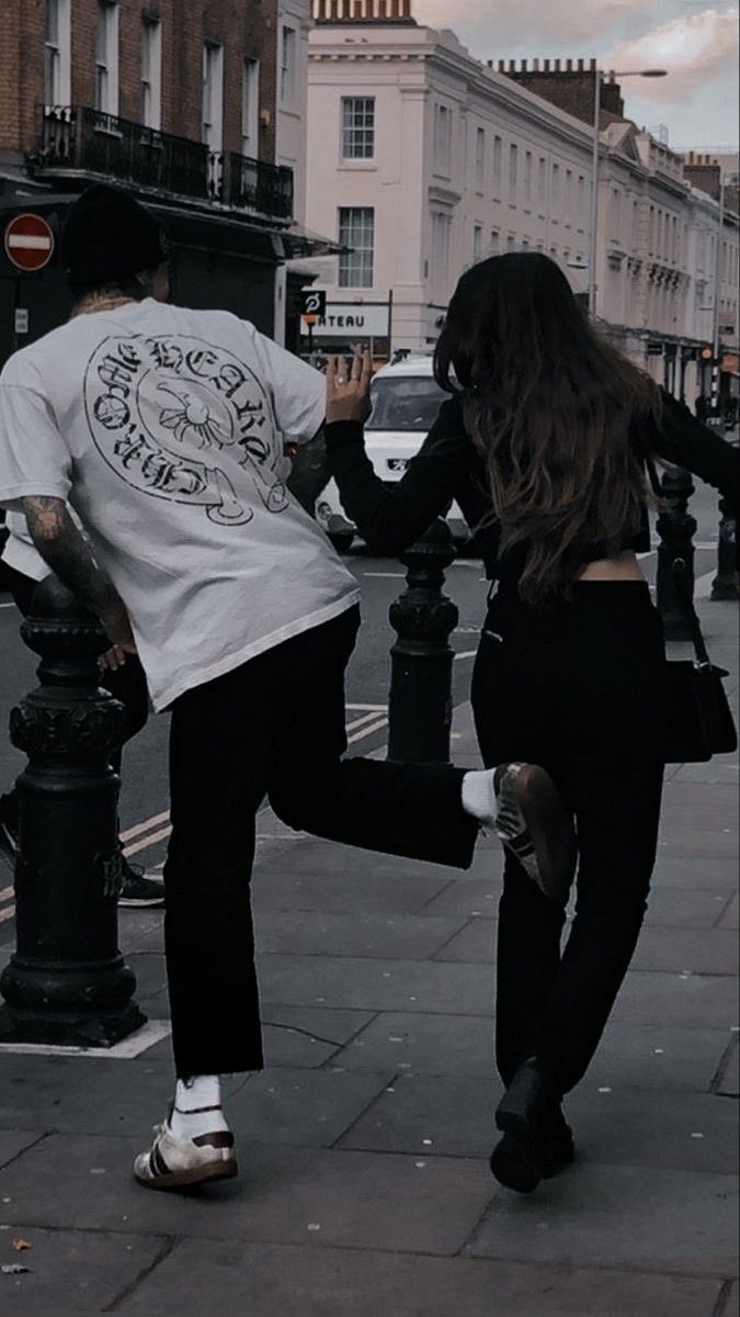 a man and woman are dancing on the sidewalk