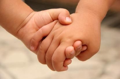 two hands holding each other in front of a white background