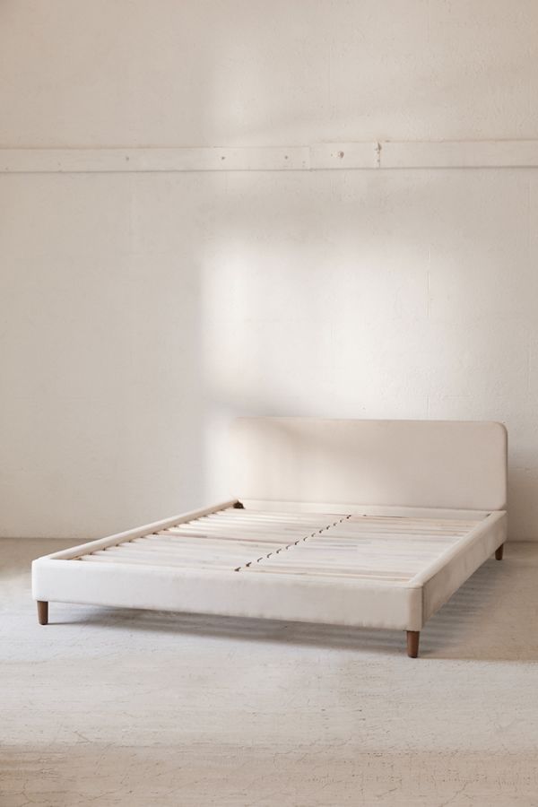 a white bed frame in an empty room