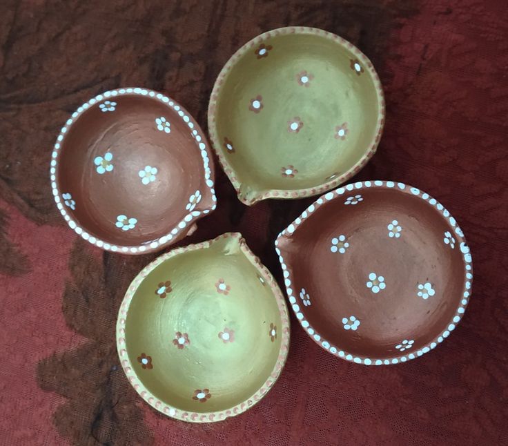 three brown and white bowls sitting on top of a red cloth covered floor next to each other