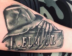 a man with a fireman's hat and boots tattoo on his arm