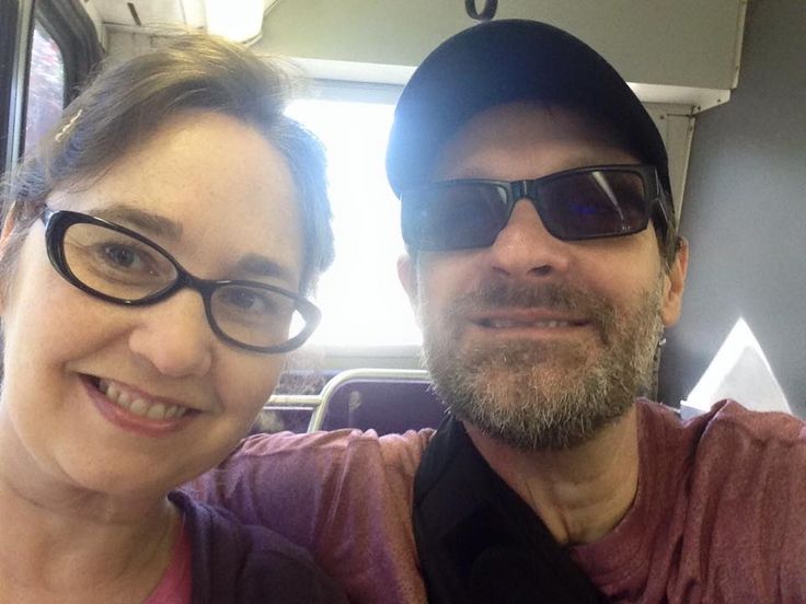 the man and woman are posing for a photo on the bus together, smiling at the camera