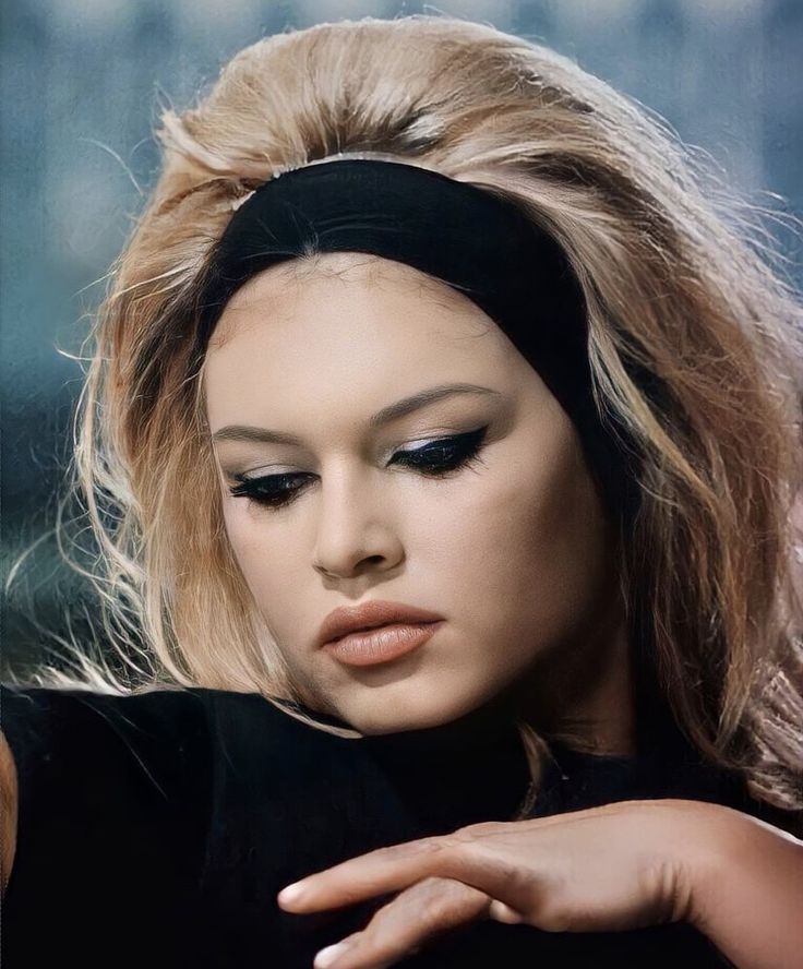 a close up of a person wearing a headband and looking at her cell phone