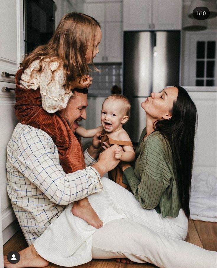 a family is sitting on the floor and laughing