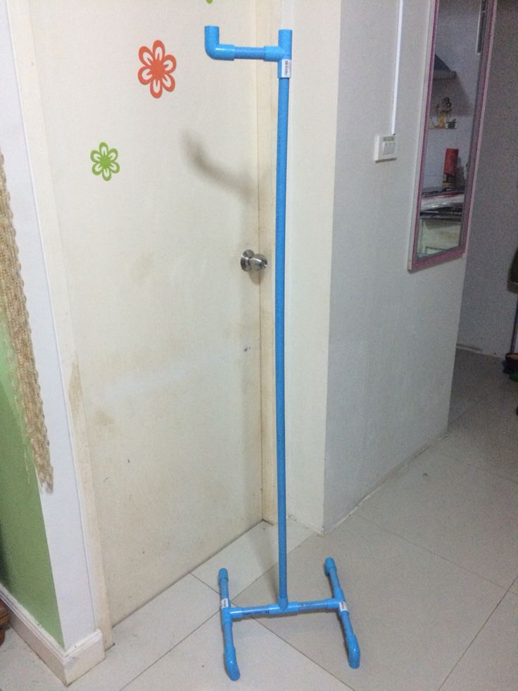 a blue pipe is in the corner of a room next to a door with flowers on it