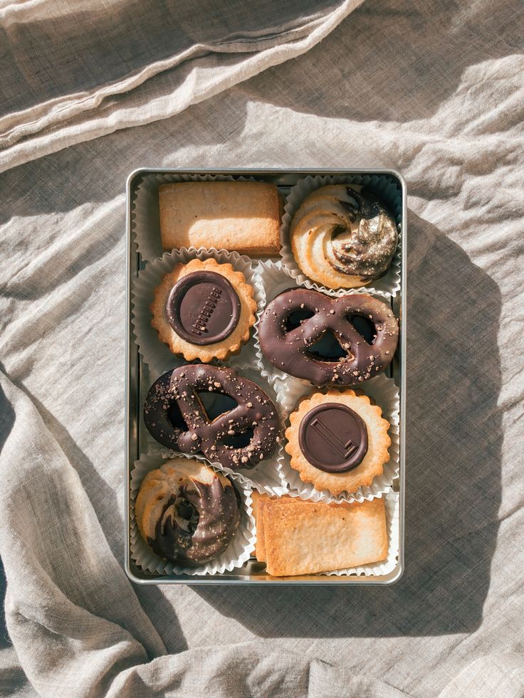 a box filled with assorted pastries on top of a bed