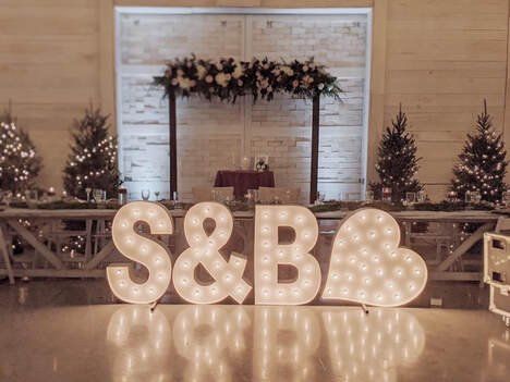 lighted letters spelling out the word s & b are displayed in front of a banquet table