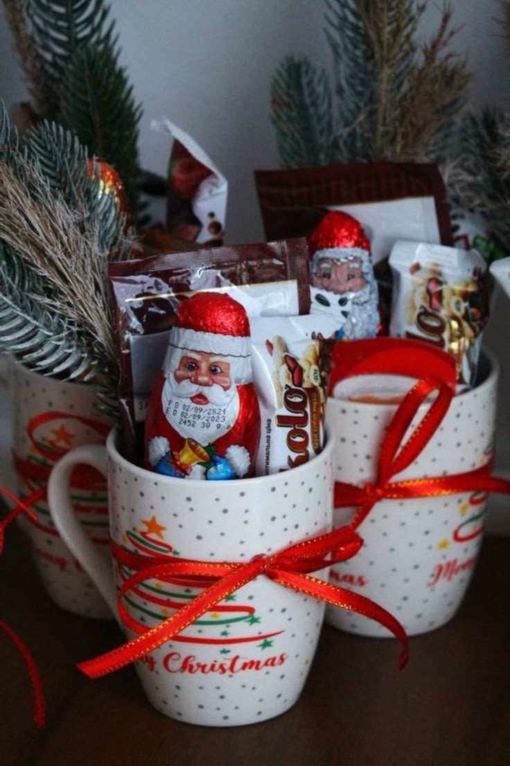 two mugs filled with candy and christmas decorations