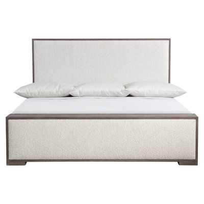 a bed with white linens and pillows on the headboard, against a white background