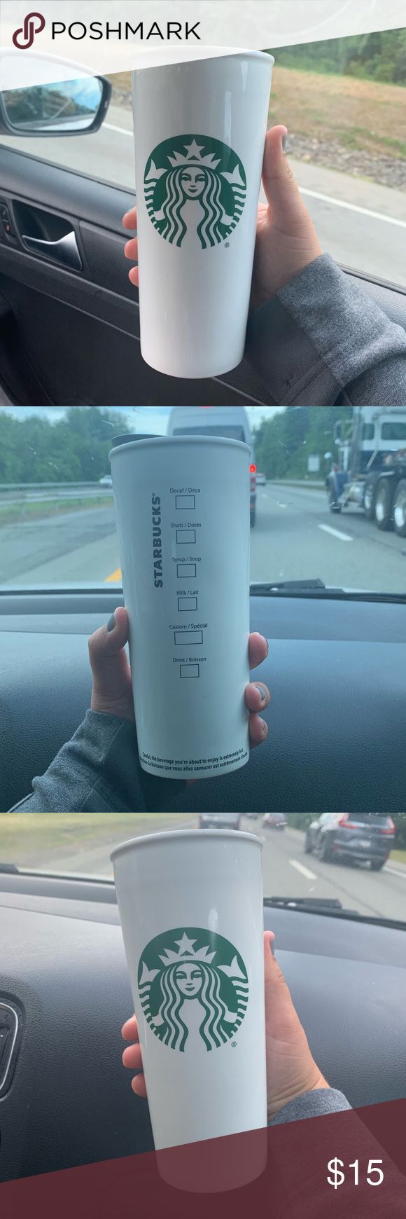 the starbucks cup is being held up by someone's hand while in their car