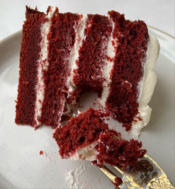 a slice of red velvet cake with white frosting