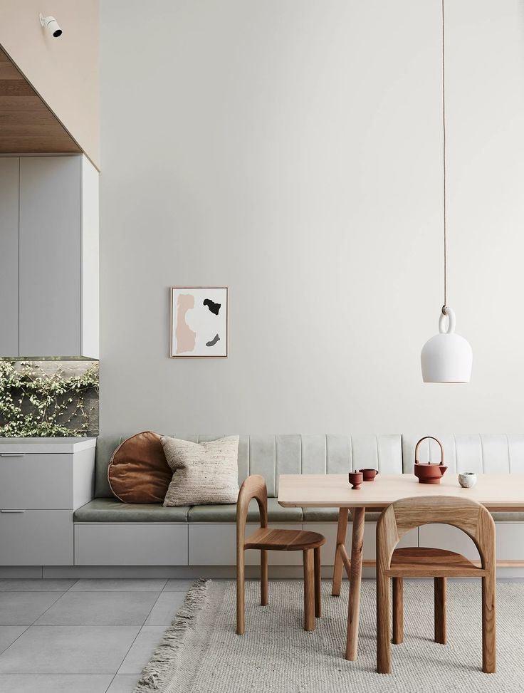 a dining room table with chairs and a bench in front of the wall next to it