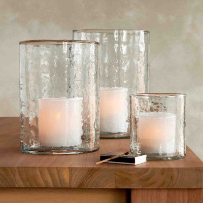 three clear glass candles on a wooden table