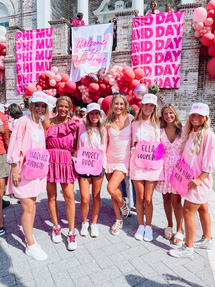 a group of girls dressed in pink posing for the camera