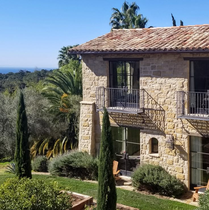 an old stone house with balconies overlooking the ocean