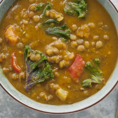 a bowl filled with beans and greens on top of a table