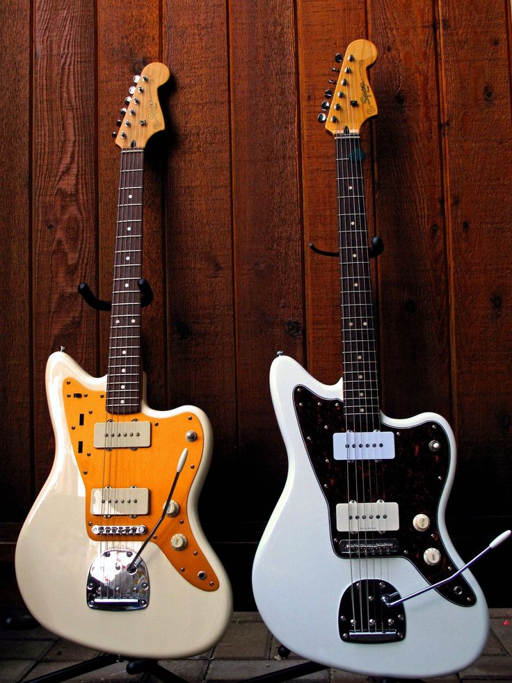 two electric guitars sitting next to each other