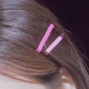 a close up of a person's hair with two pink toothbrushes in it