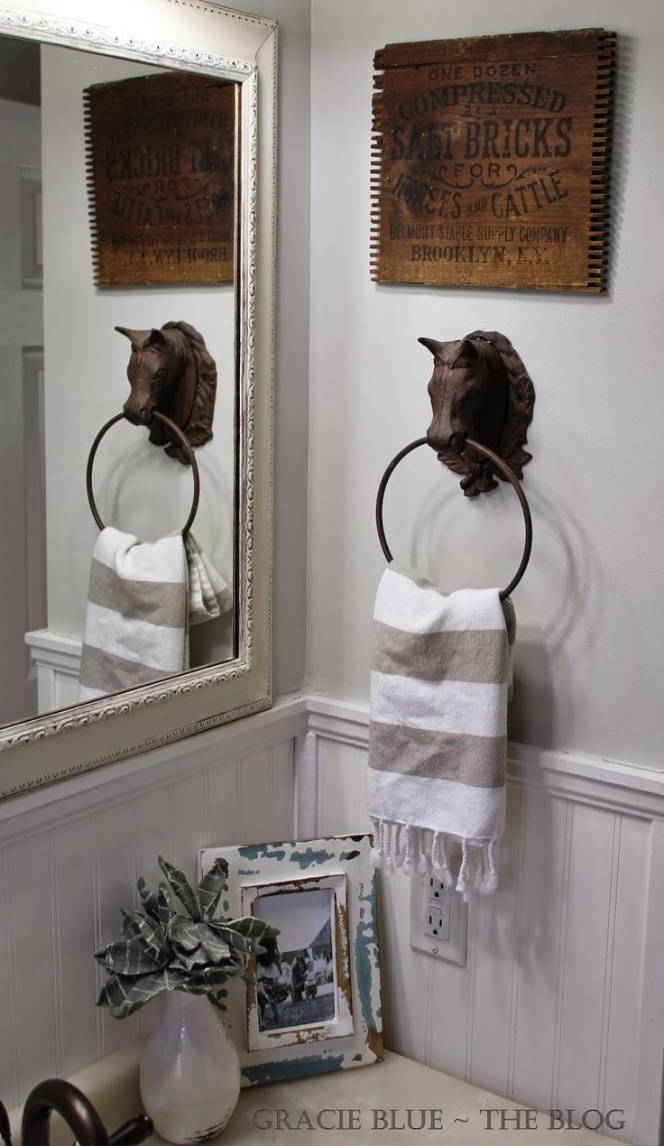 a bathroom sink with two towels hanging on the wall and an old fashioned mirror above it