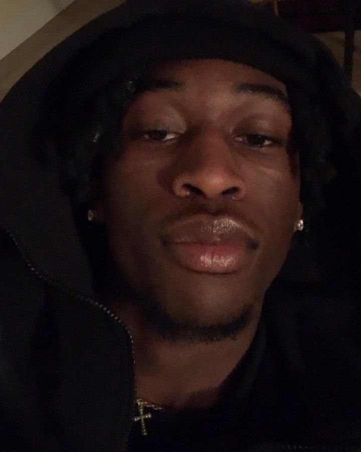 a man in a black hoodie is staring at the camera with his eyes closed