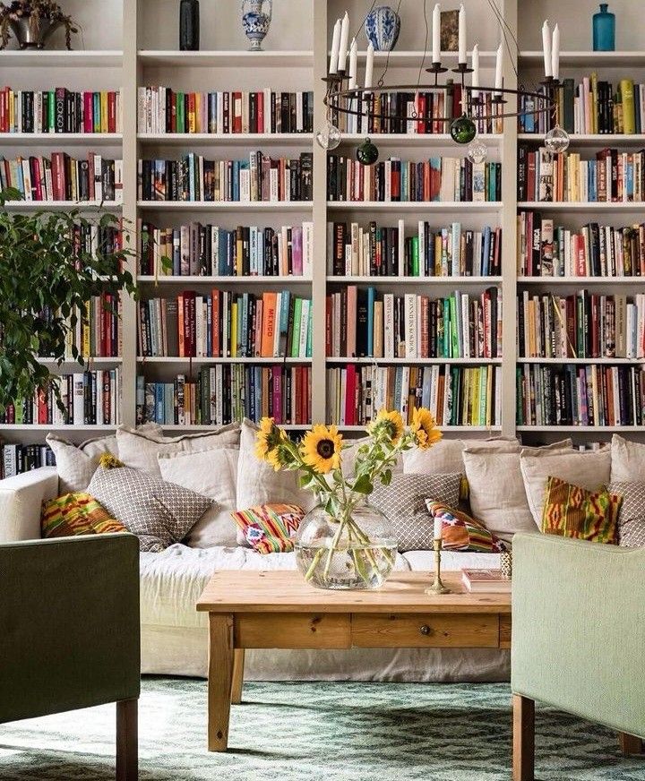 a living room filled with lots of furniture and bookshelves full of books on shelves