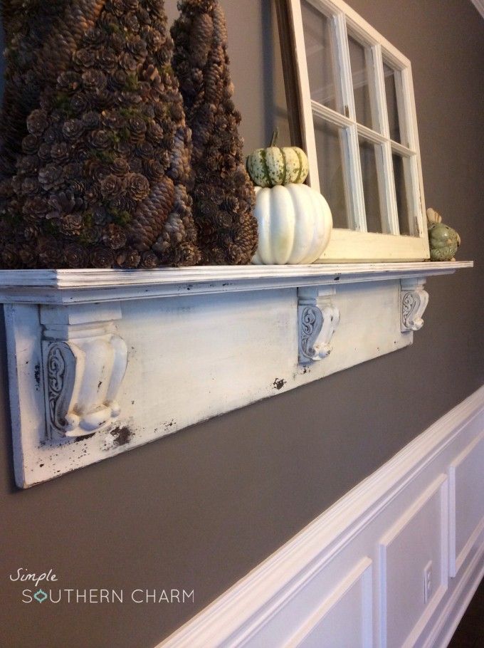 a window sill with pine cones and gourds on the ledge above it