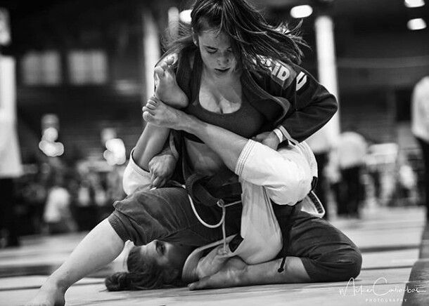 a woman is holding another woman in her arms while they both are performing a kick