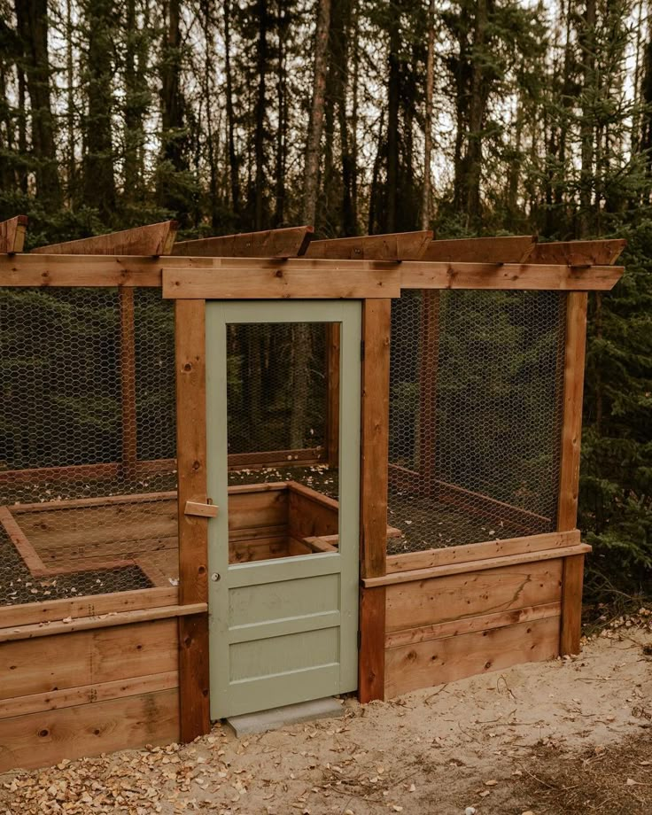 a chicken coop built into the side of a wooded area