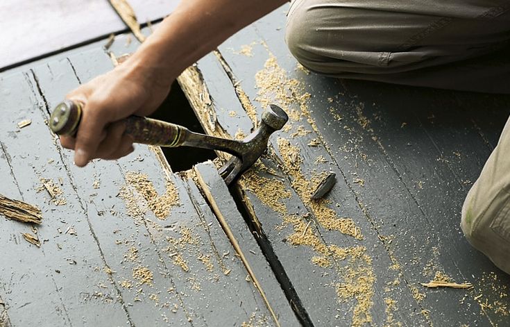 a man is working on the roof of his house with hammers and pliers