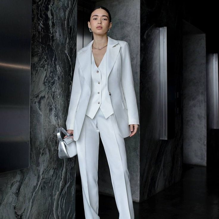 Elevate your bridal style with our exquisite women's 3-piece suit, a blend of elegance, sophistication, and modern flair. Tailored to perfection, this ensemble is designed to make you feel confident and radiant on your special day. Crafted with meticulous attention to detail, our white pantsuit exudes timeless charm and grace. Whether you're walking down the aisle or celebrating at your reception, this suit is a symbol of your unique style and individuality. Each piece of this ensemble, from the White Tailored Pants For Semi-formal Occasions, Semi-formal Tailored White Pants, White Tailored Semi-formal Pants, Modern White Formal Pants, Chic White Pants For Tailoring, Elegant Tailored Three-piece Suit For Evening, Tailored Elegant Three-piece Suit For Evening, Luxury White Pants For Wedding, Luxury White Evening Pants