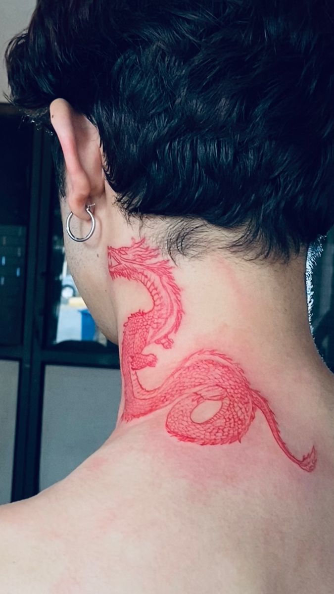 the back of a woman's neck with a red dragon tattoo on her left side